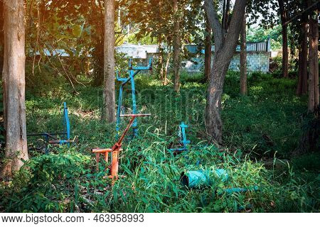 Old Outdoor Exercise Equipment So Worn Out And Covered In Trees In Outdoor Exercise Park. Old Abando