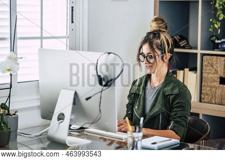 Professional Female Worker At Home In Smart Working Activity Using Computer And Headphones. Alternat
