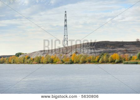 Højspændingslinie og elektricitet Pylon på kysten af floden.