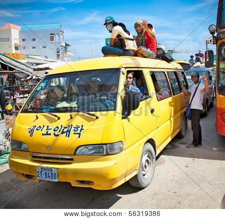 NEAK LEUNG, CAMBODIA - NOV 19, 2013: Passengers sit atop a very overload vehicle in Neak Leung on Noveber 17, 2013, Cambodia. This kind of domestic transportation carries between 16 to 30 passengers.