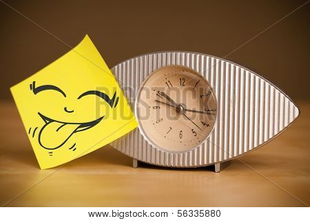 Drawn smiley face on a post-it note sticked on alarm clock