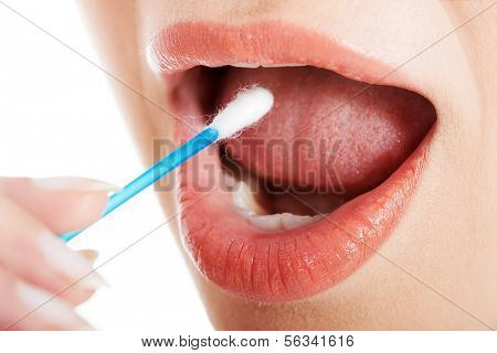 Young woman putting ear stick into mouth. Close up.