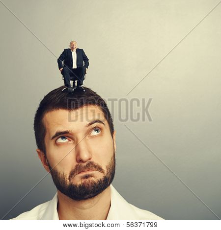 surprised man looking up at small man on the head