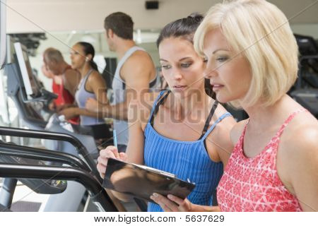 Osobní trenér odebíraném žena na běžecký pás