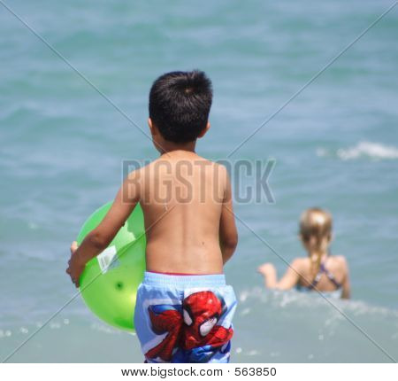Muchacho en la playa con bola