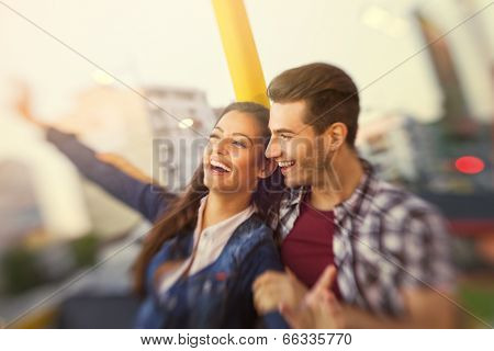 Young smiling couple having a ride on a ferris wheel