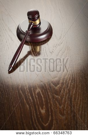Dark Wooden Gavel Abstract on Reflective Table with Room for Text.