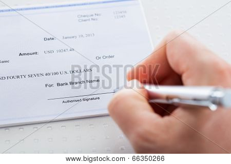 Hand With Pen Over Checkbook