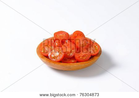 halved cherry tomatoes served in the wooden bowl