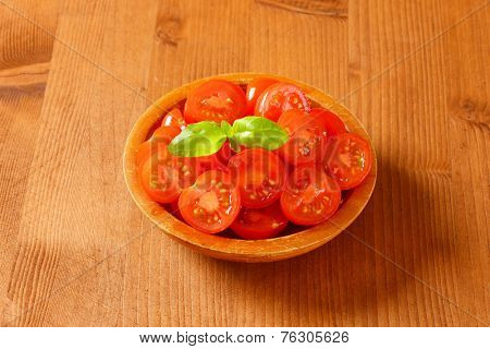 overhead view of portioned cherry tomatoes served in the wooden bowl
