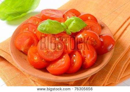 detail of halved cherry tomatoes in the bowl with fabric linen