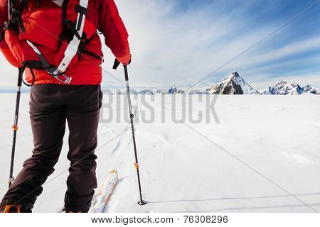 Mountaineer exploring a glacier with the skis during a high-altitude winter expedition in the european Alps. In background the Matterhorn, Zermatt, Switzerland, Europe.