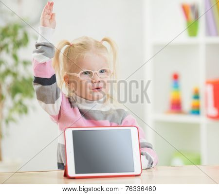 happy child in glasses with hand up and tablet pc screen