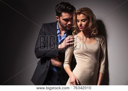 Handsome young business man looking at his lover while toching her shoulder with his right hand.