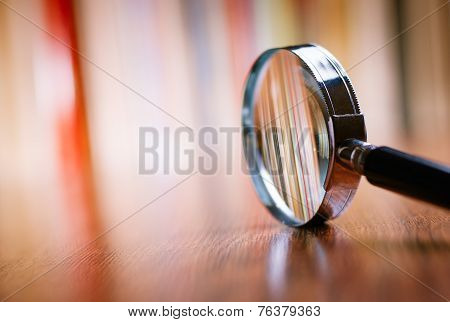Close Up Magnifying Glass Leaning On Wooden Table