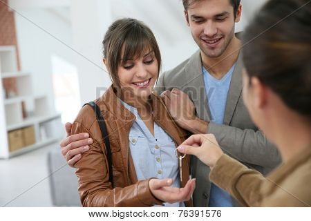 Happy young couple getting key of their new place