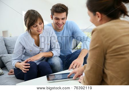 Young couple signing financial contrat on digital tablet