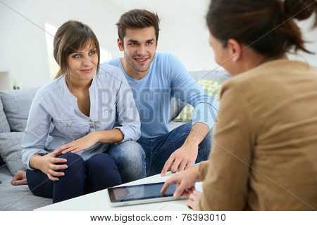 Young couple signing financial contrat on digital tablet