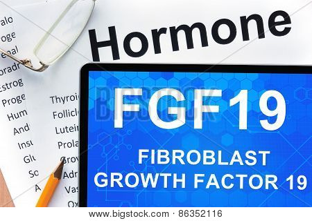 Papers with hormones list and tablet  with words fibroblast growth factor 19 (FGF19) .