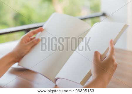 Hands open Blank catalog, magazines,book mock up on wood table with coffee