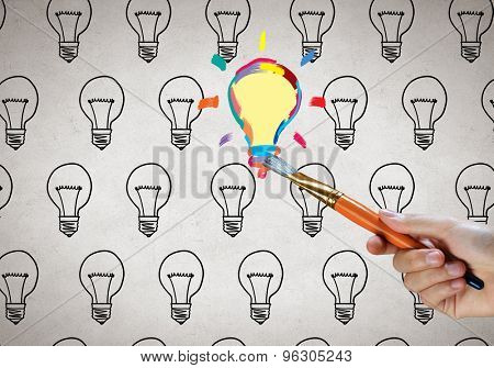 Close up of hand darwing light bulb with marker
