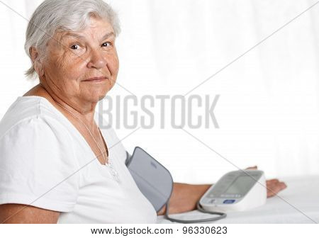 Elder Woman Measuring Blood Pressure With Automatic Manometer