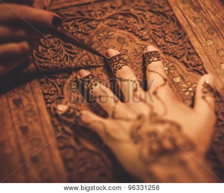 Drawing process of henna menhdi ornament on woman's hand 