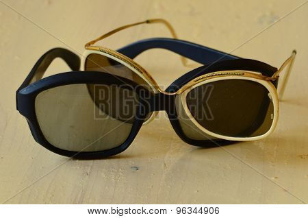 Retro black and white sunglasses on wooden background.