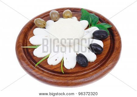 dairy products : feta white cheese sliced on cut board with olives and basil leaves isolated over white background