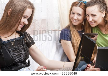 Portrait Of Three Young Caucasian Girlfriends With Laptops Looking For The Information Together.