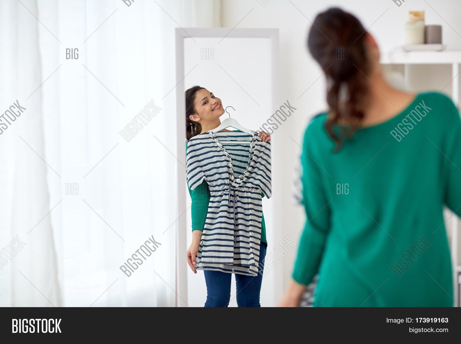 Женская одежда. Примерка одежды в магазине. Примерочная на рынке. Примерочные в магазинах одежды красивая. Женщина выбирает одежду.