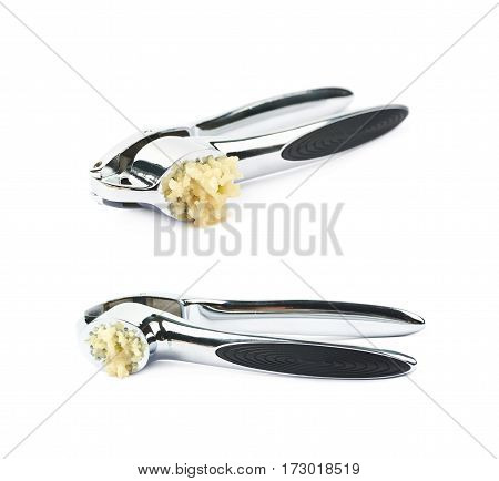 Used metal garlic press utensil with a crushed clove, composition isolated over the white background, set of two different foreshortenings