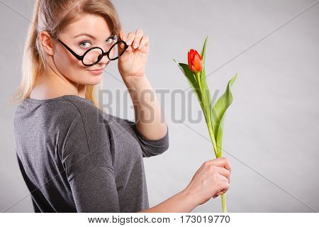 Leisure feelings flora nature beauty feminine concept. Seducive nerdy girl holding tulip. Young blonde lady with red flower.