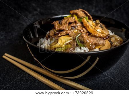 Asian rice with beef meat and vegetagles on dark background