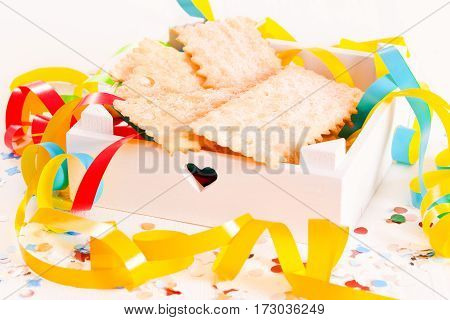 Carnival pastry with confetti on wooden table.
