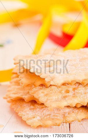 Carnival pastry with confetti on wooden table.