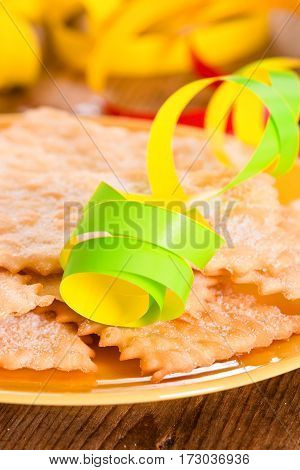 Carnival pastry with confetti on wooden table.