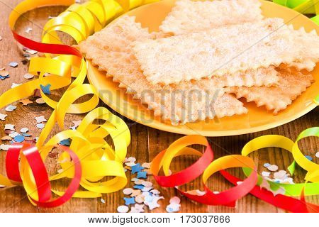 Carnival pastry with confetti on wooden table.