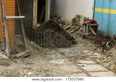 Heap of black sands on renovation project of a house near a white brick wall photo taken in Depok Jakarta Indonesia java