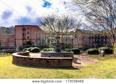 Prattville Alabama USA - January 28 2017: A view of the fountain in Heritage Park in downtown Prattville overlooking the old Daniell Pratt Cotton Gin Company.