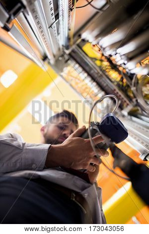Technician using digital cable analyzer in server room