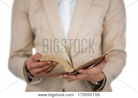 Mid section of Businesswoman flips through the pages of a book on white background