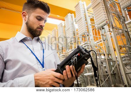 Technician using digital cable analyzer in server room