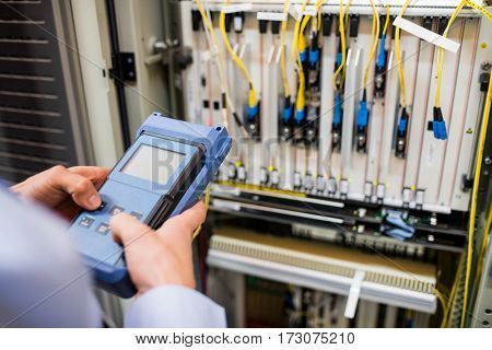 Technician using digital cable analyzer in server room