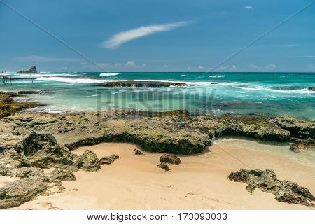 Sunny beach near Koggala - Sri Lanka The area famous for its distinct stilt fishermen, who erect a single pole in the chest-deep water on the beach, just few meters off-shore. Splittoned, vivid image.
