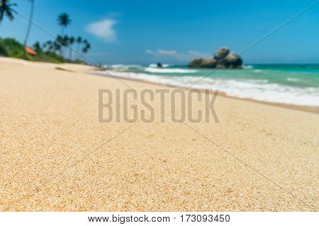 Sunny beach near Koggala - Sri Lanka The area famous for its distinct stilt fishermen, who erect a single pole in the chest-deep water on the beach, just few meters off-shore. Splittoned, vivid image.