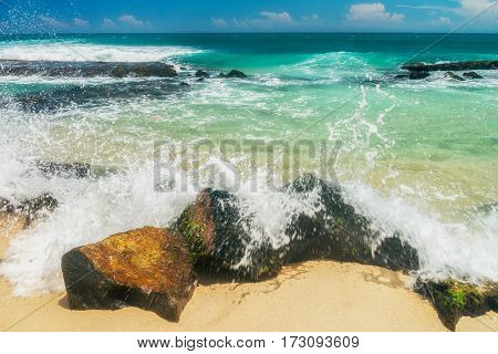 Sunny beach near Koggala - Sri Lanka The area famous for its distinct stilt fishermen, who erect a single pole in the chest-deep water on the beach, just few meters off-shore. Splittoned, vivid image.