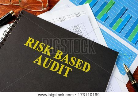 Book with title risk based audit on a table.