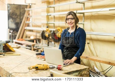 Woman Working In A Woodshop With Laptop