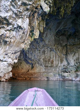 Entrance of a cave seen from the outside and the bow of a boat